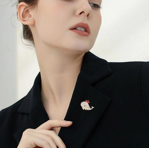 Close-up of sparkling dolphin whale brooch with crystals on a black suit lapel