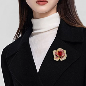Broche camélia élégante avec cristal rouge et strass roses sur un manteau de laine
