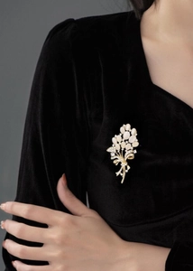 Broche fleur en pierre œil-de-chat et strass portée sur un vêtement en velours