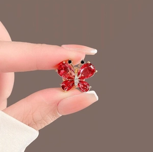 Elegant gold butterfly brooch with deep red crystal wings and sparkling micro diamonds
