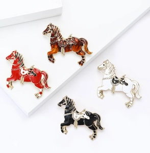 Detailed macro view of horse brooches with enamel finish and crystal inlay craftsmanship