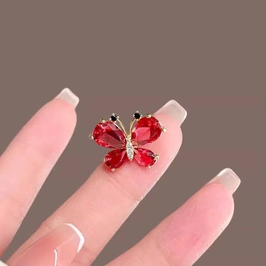 Elegant red crystal butterfly stud earrings in gold finish with small diamond accents
