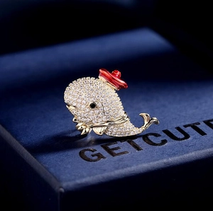 Macro shot of cute sparkling dolphin brooch with crystals on a navy jewelry box