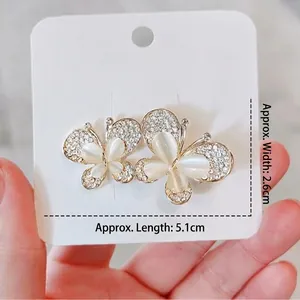 Spilla a farfalla elegante in oro con pietra occhio di gatto e cristalli scintillanti