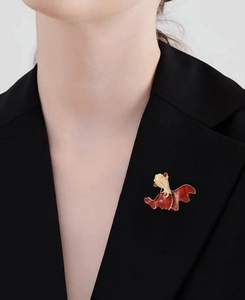 Detailed close-up of a red goldfish brooch with sparkling zircon on black suit jacket