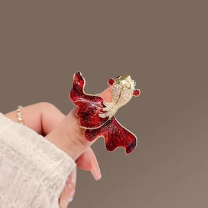 Golden goldfish ring with red enamel fins and sparkling zircon stones on female hand