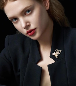 Close-up of elegant gold butterfly brooch with mother of pearl on a black suit blazer
