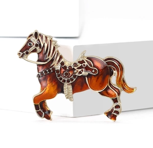 Detailed macro of a golden horse brooch with enamel gradient and sparkling rhinestones