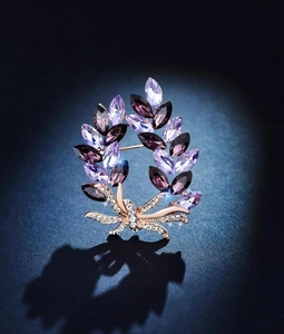 Detail of a purple crystal wreath brooch with marquise stones and a micro-set zircon bow