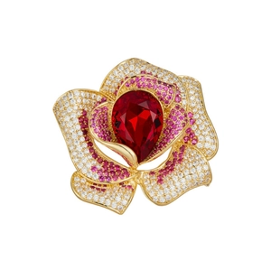 Détail macro d'une broche rose avec cristal rouge en poire et pétales de fleurs roses