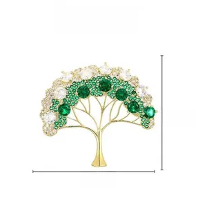 Détail d'une broche sapin de Noël dorée avec cristaux verts et blancs, taille 3,7cm sur 4,2cm