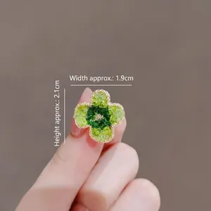 Elegante goudomrand groene klaverbloembroche accessoire getoond in de hand
