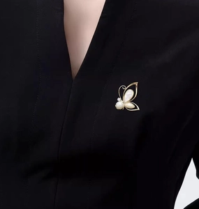 Detailed view of the gold butterfly brooch with pearls and mother of pearl inlay