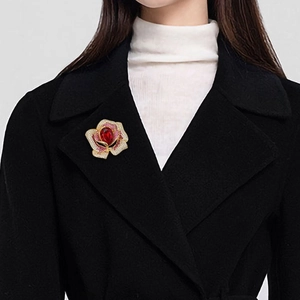 Broche rose élégante avec cristal rouge et pétales pavés sur manteau noir en laine