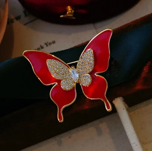 Élégante broche papillon en émail rouge avec cristaux étincelants et finitions dorées