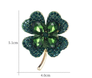 Gros plan sur la broche trèfle à quatre feuilles dorée avec strass verts et dimensions