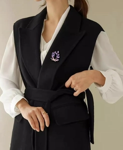 Detailed view of a purple marquise crystal flower brooch pinned on a black suit lapel