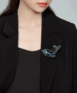 Détail d'une broche baleine bleu marine avec cristaux brillants sur un revers
