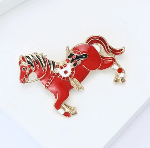 Exquisite horse brooch with red enamel finish and sparkling crystals in gold plating