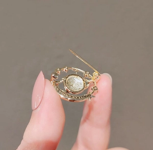 Detailed back view of gold-plated crescent moon brooch with star accents and safety pin