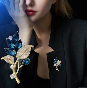 Close-up of elegant orchid brooch with navy blue crystals and zircons on black suit