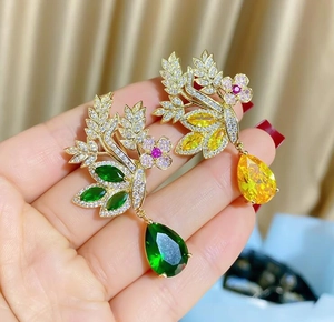 Gros plan détaillé de boucles d'oreilles florales dorées avec gemmes en forme de goutte