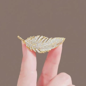 Spilla a piuma dorata con diamanti incastonati per risvolti e accessori di lusso