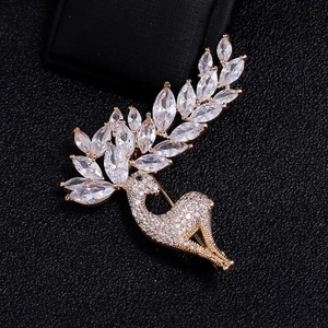 Détail macro d'une broche cerf en cristal avec zircons scintillants sur fond noir texturé