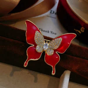 Broche papillon en émail rouge élégante avec cristaux et finition dorée sur velours