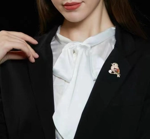 Colorful magpie bird brooch with vibrant crystals pinned on a formal black blazer suit