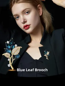 Macro detail of elegant blue leaf brooch with gold base and sapphire crystal inlay