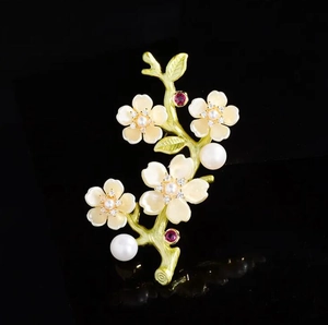Elegant peach blossom branch brooch with sparkling crystals and pearls on black background