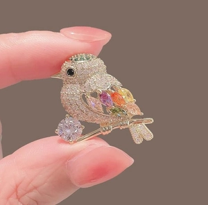 Macro shot of colorful magpie brooch with cubic zirconia and vibrant gemstones
