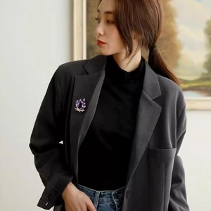 Elegant purple crystal wreath brooch pinned on a grey suit lapel for women fashion