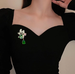 Broche fleurie élégante avec cristal vert en goutte et détails dorés brillants