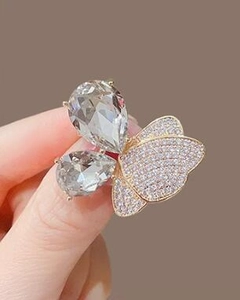 Gros plan détaillé d'une broche papillon dorée avec cristaux en poire et pavage de zircons