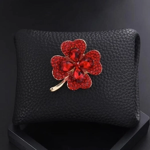 Broche trèfle élégante avec strass rouges sur base en métal doré et cuir grainé noir chic