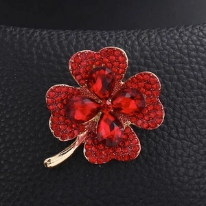 Broche trèfle à quatre feuilles élégante avec strass rouges sur base dorée