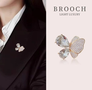 Détail d'une broche papillon en cristal sur un costume noir et fond rose élégant