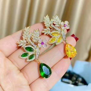 Exquise broche oiseau dorée avec pierres précieuses gouttes vert émeraude et jaune
