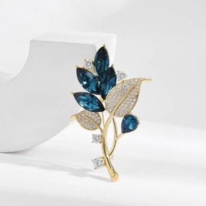 Elegant gold orchid brooch with blue marquise crystals and white zircon leaf accents