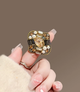 Macro view of vintage gold ring with amber stone, pearls and crystals details