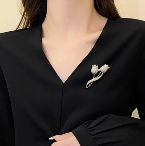 Broche tulipe élégante en or avec incrustation de diamants sur un col en V noir