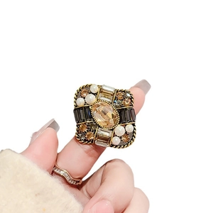 Vintage luxury brooch with amber stone, pearls, and crystals on a gold rope setting