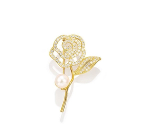 Detailed view of camellia brooch with gold plating, white crystals, and elegant pearl