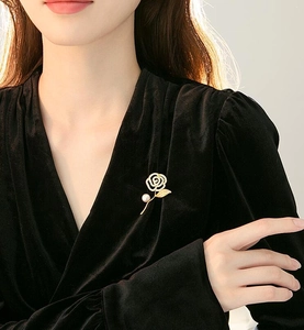 Detailed view of camellia brooch with crystal petals and pearl on black velvet blazer