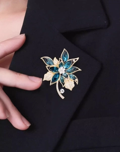 Nahaufnahme einer eleganten Blumenbrosche mit blauen Markasit-Kristallen und weißen Diamanten