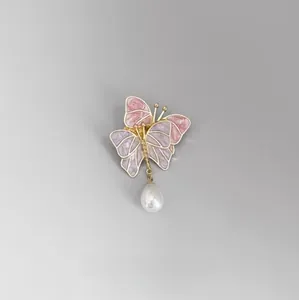 Détail de la broche papillon en émail rose et violet avec une perle en forme de goutte
