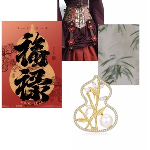 Detail of gold gourd brooch with bamboo motif and white pearl on luxury suit lapel