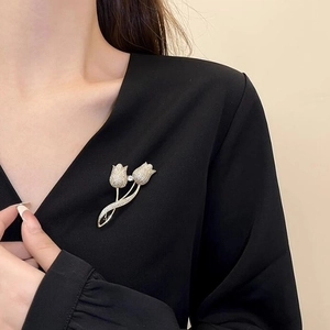 Élégante broche tulipe dorée avec cristaux scintillants fixée sur un costume noir